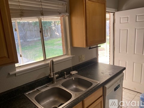 A kitchen with a double sink and a window.