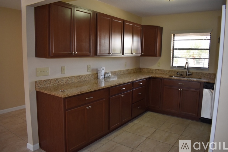 A kitchen with brown cabinets and a granite countertop.