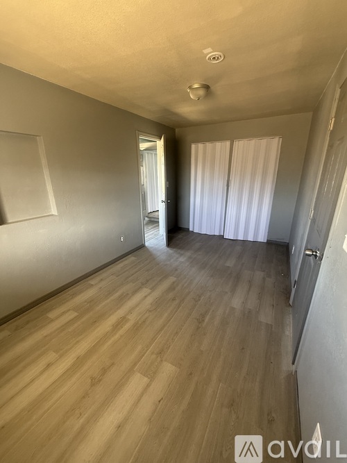 A room with wooden flooring and a white door.