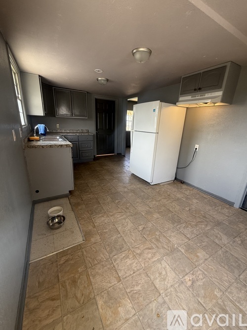 A kitchen with a white refrigerator and a dishwasher.