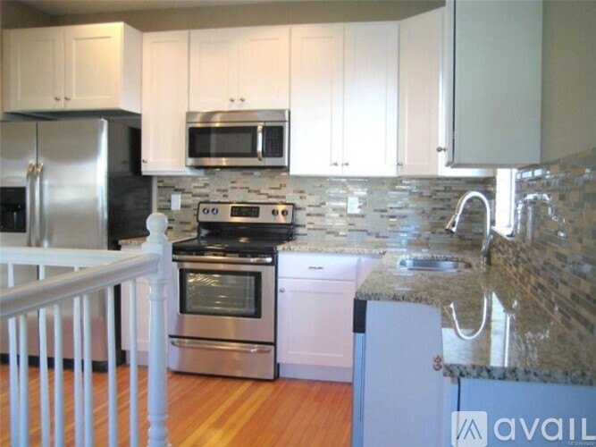 A kitchen with white cabinets and a granite counter top.