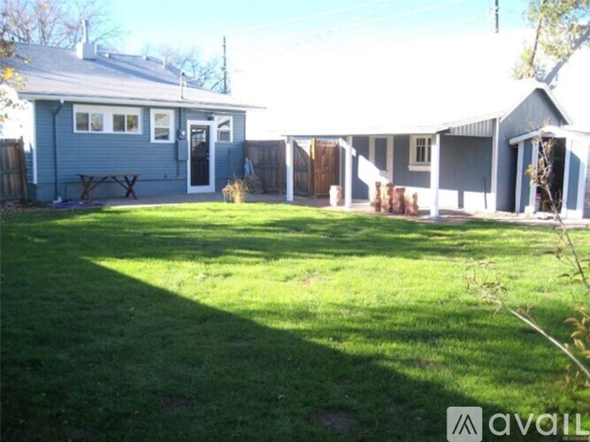 A house with a blue exterior and a green lawn in front.