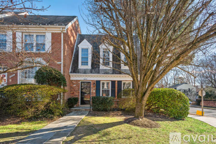 A brick house with a tree in front.