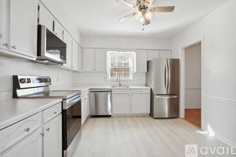A kitchen with white cabinets and stainless steel appliances.