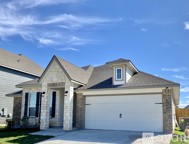 A house with a garage door and a window on the side.