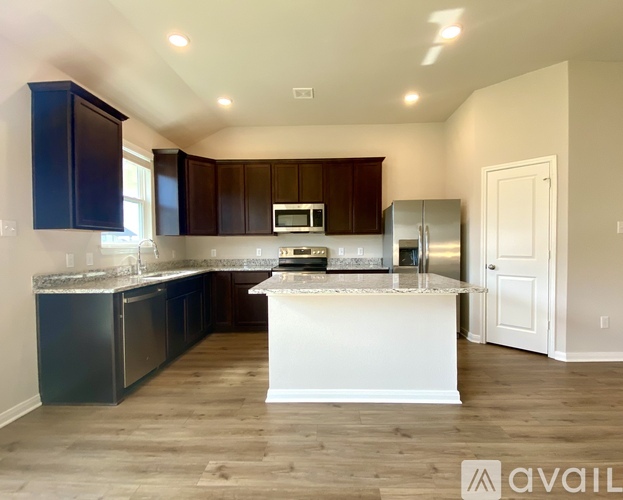 A kitchen with dark brown cabinets and a white island.