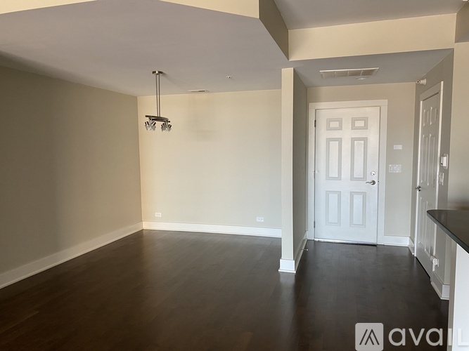 A spacious room with wooden floors and a white door.