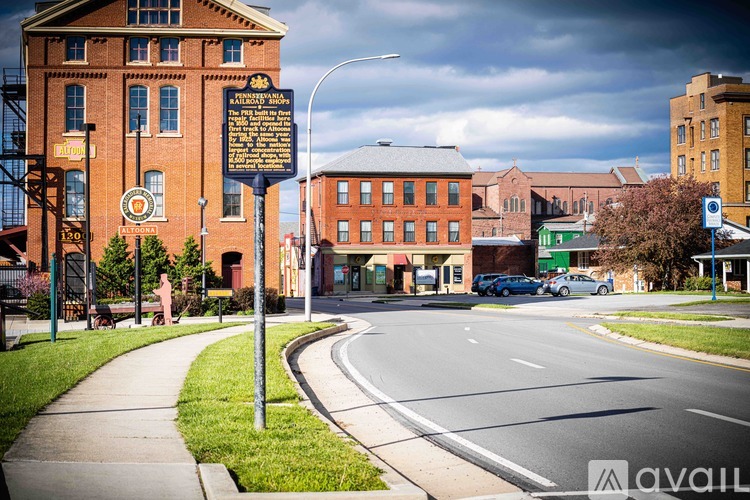 A street view with a signpost in the foreground and a building with a clock tower in the background.
