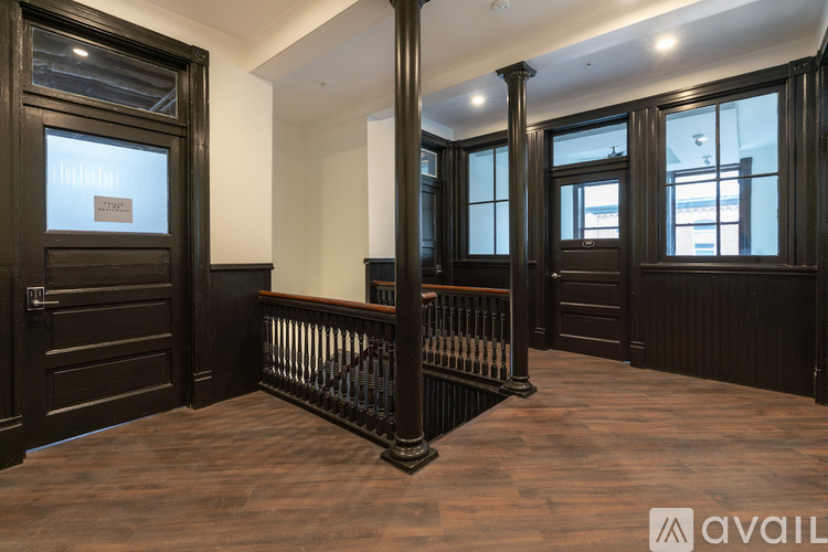 A room with dark wood floors and a balustrade.