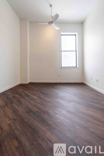 A room with wooden flooring and a window.