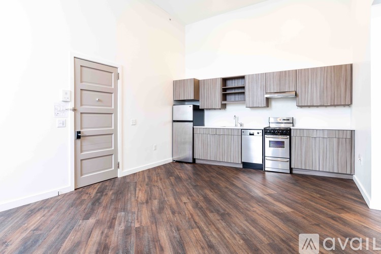 A kitchen with wooden floors and a white wall.