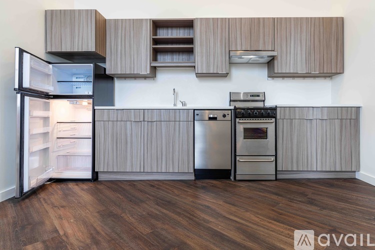 A kitchen with wooden cabinets and a stainless steel refrigerator.