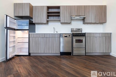 A kitchen with wooden cabinets and a stainless steel refrigerator.