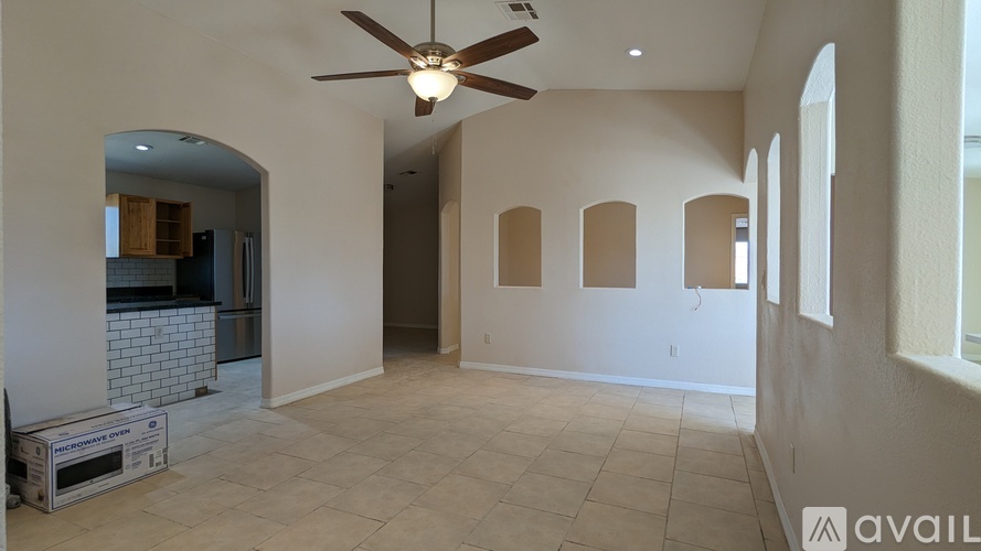 A spacious room with a ceiling fan and tiled flooring.