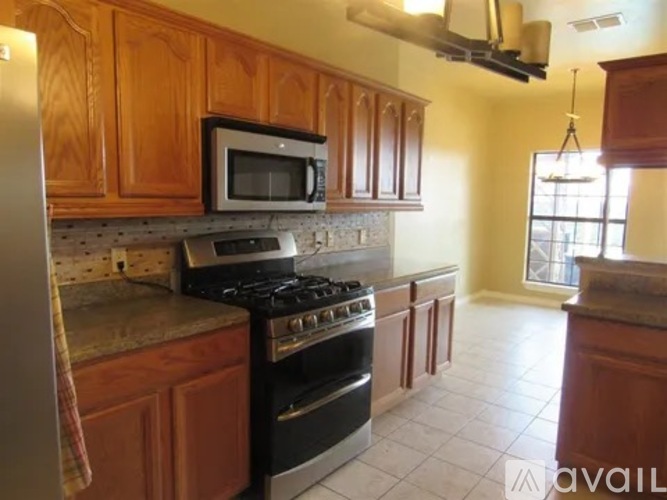 A kitchen with wooden cabinets and a black stove top oven.