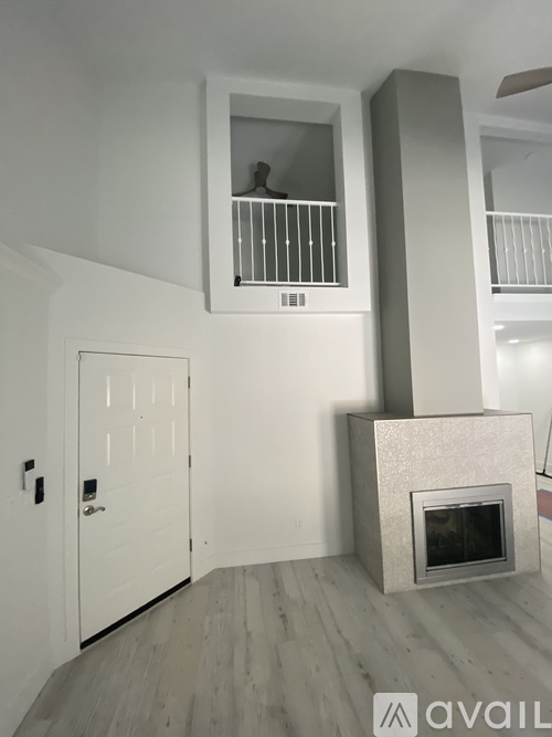 A modern living room with a fireplace and a balcony.