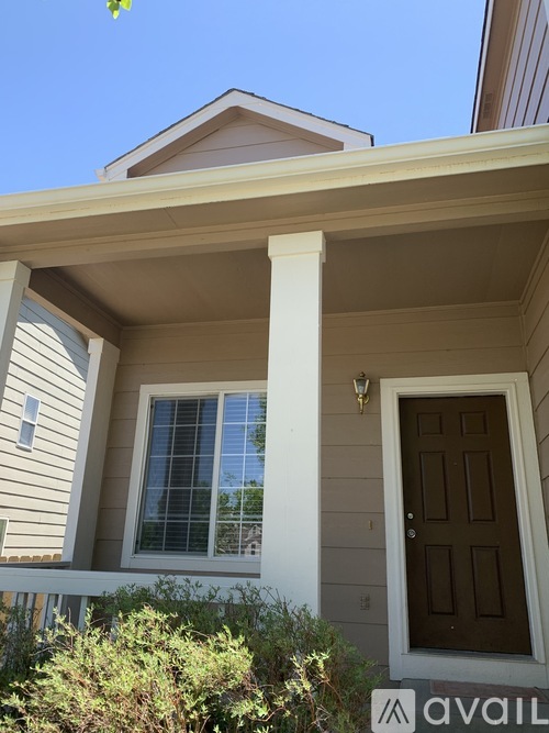 A house with a brown door and a window with a white frame.