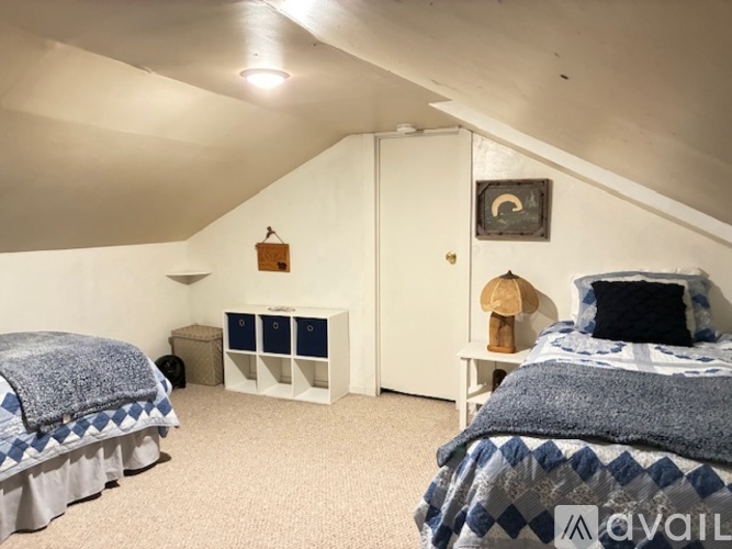 A bedroom with two beds and a dresser.