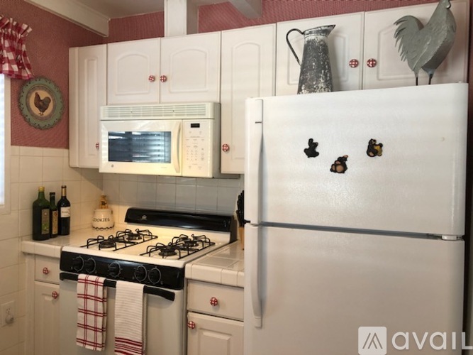 A white refrigerator with decorations on it in a kitchen.