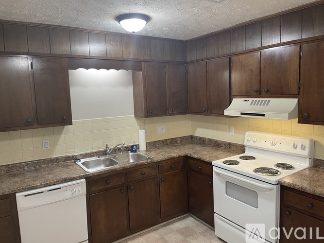 A kitchen with brown cabinets and a white oven.