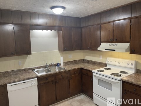 A kitchen with brown cabinets and a white oven.