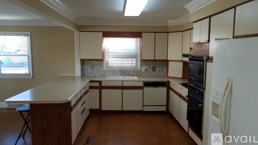A kitchen with wooden floors and white appliances.