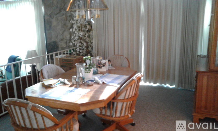 A dining room with a wooden table and chairs.