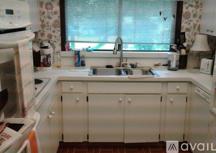 A kitchen with white cabinets and a sink.