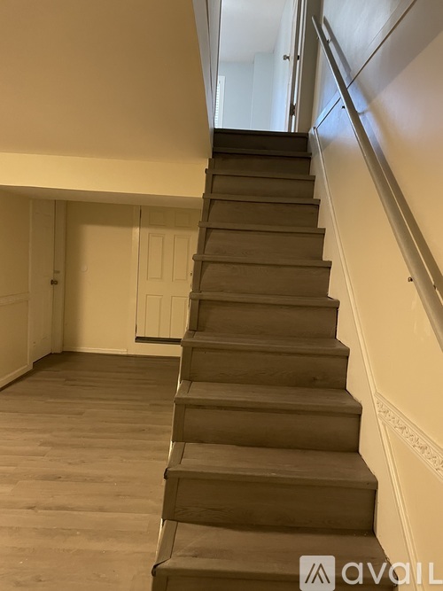 A staircase with wooden steps and a metal handrail.