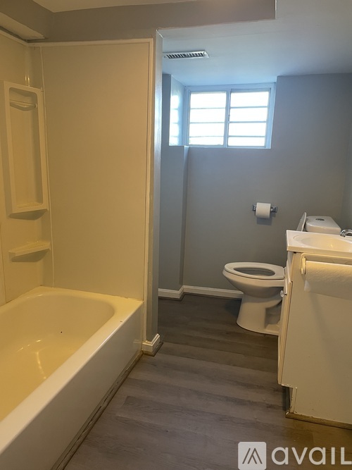 A bathroom with a tub, toilet, and sink.