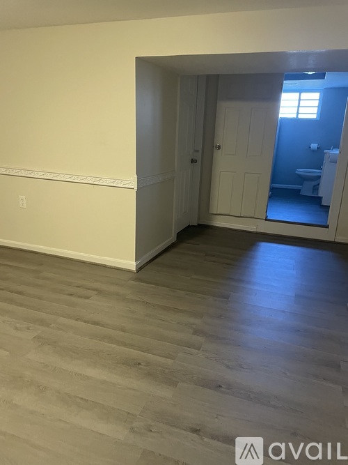 A room with a wooden floor and a white door.