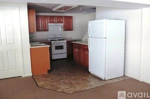 A kitchen with white appliances and brown cabinets.