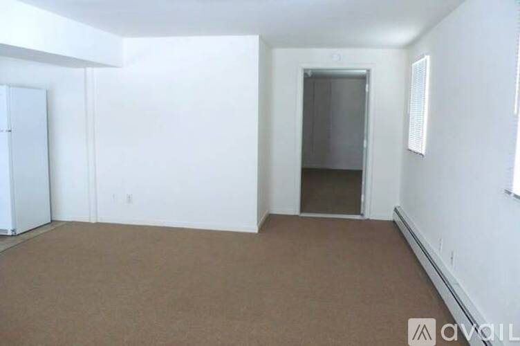 A room with a brown carpet and white walls.