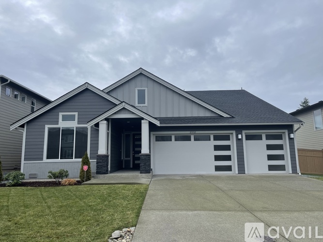A two-story house with a garage and a driveway.