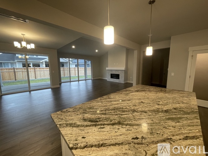 A spacious room with a marble countertop and wooden flooring.