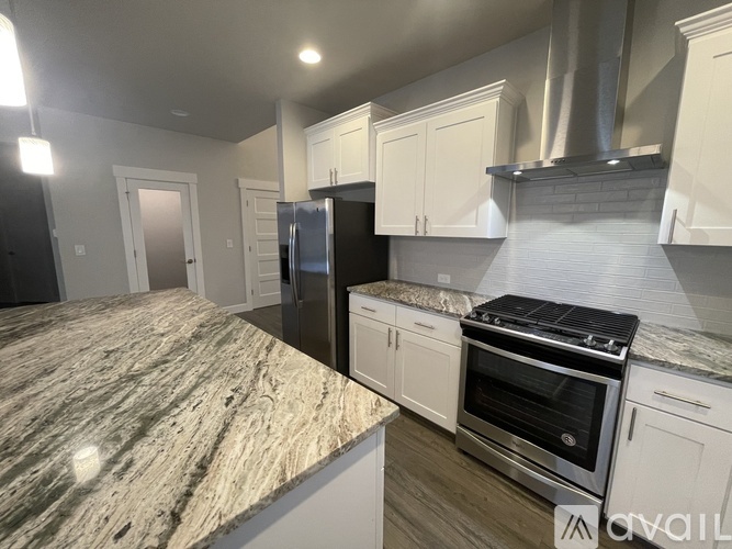 A kitchen with granite countertops and stainless steel appliances is available for rent.