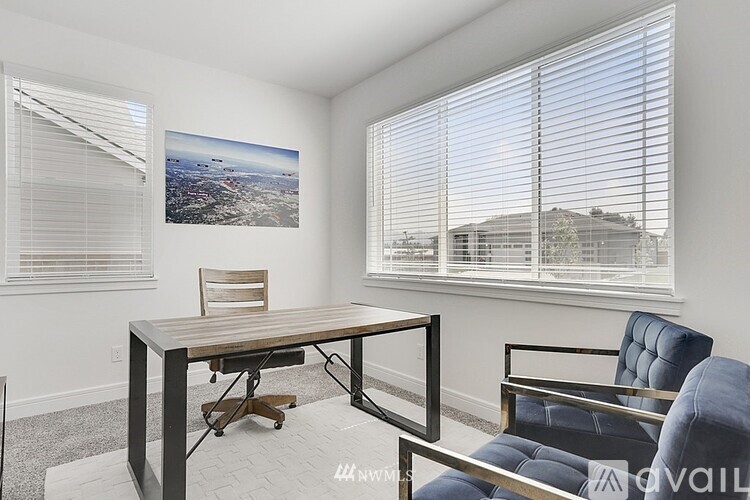 A room with a table, chairs and a picture on the wall.