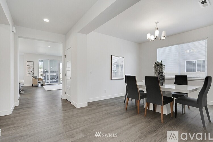 A dining room with a table and chairs.