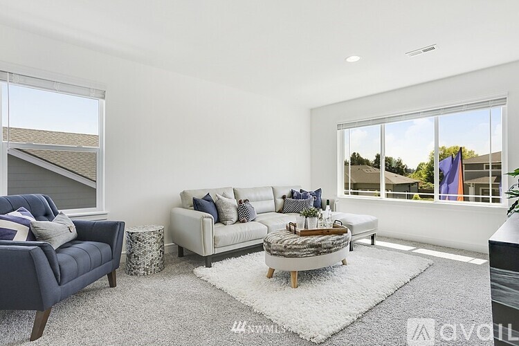 A living room with a white couch and a blue armchair.