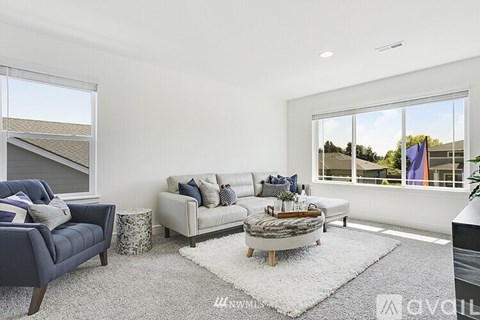A living room with a white couch and a blue armchair.