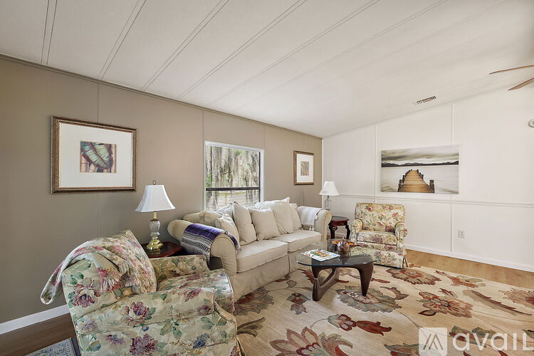 A living room with a floral chair and a white couch.