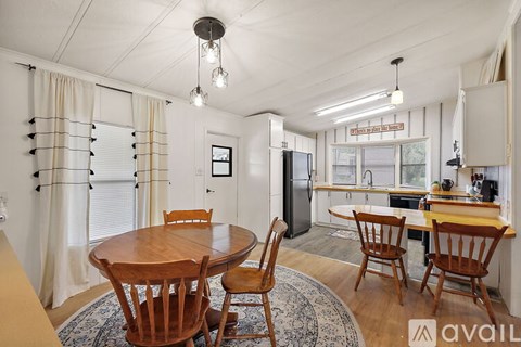 A dining room with a wooden table and chairs.