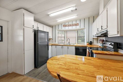 A kitchen with a wooden table and a refrigerator.