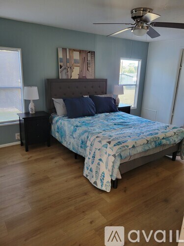 A bedroom with a bed, nightstand, and a ceiling fan.
