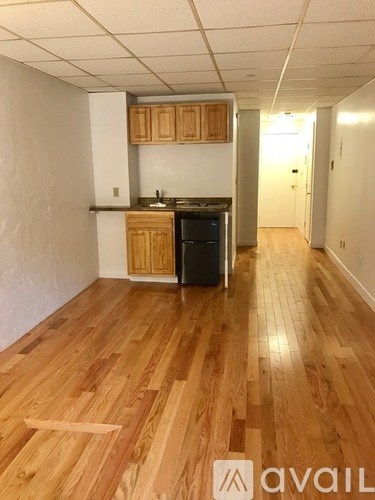 A kitchen with wooden floors and cabinets.