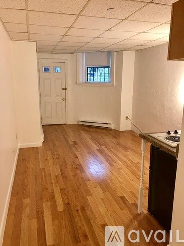 A room with wooden flooring and a white door.