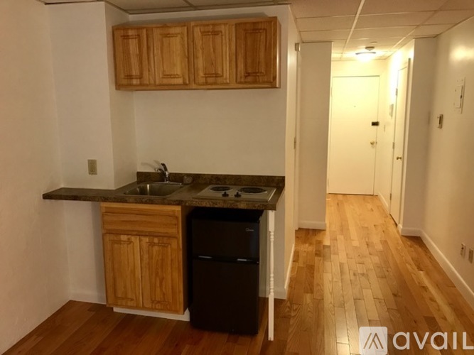 A kitchen with wooden cabinets and a black dishwasher.