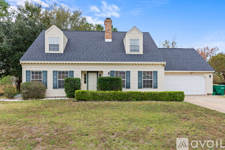 A house with a blue roof and white walls is for sale.