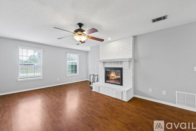 A living room with a fireplace and a ceiling fan.