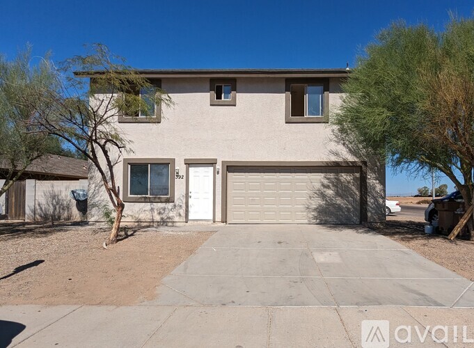 A house with a garage door and a driveway in front.